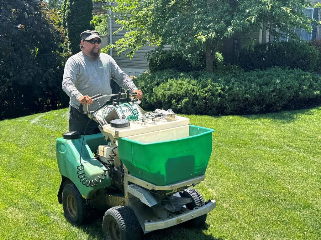 Green Image Lawn Care worker on spreader